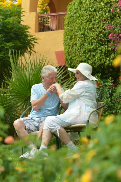 Pareja mayor sentada en el jardín del hotel tropical —  Fotos de Stock