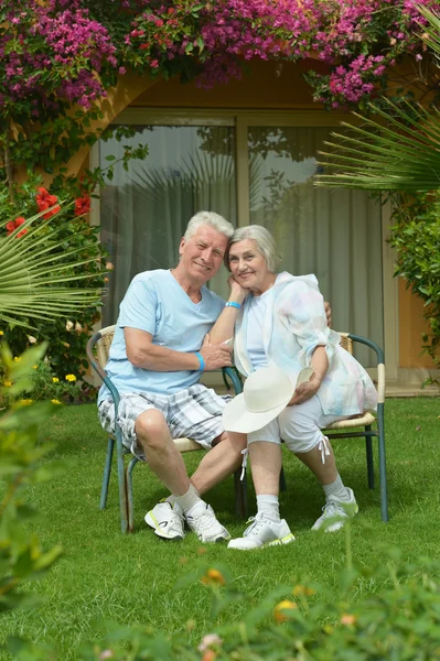 Starší pár sedící v tropic hotel garden — Stock fotografie