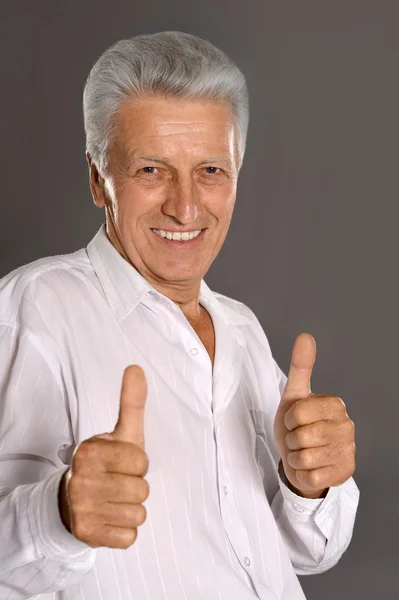 Старший чоловік показує великі пальці вгору — стокове фото