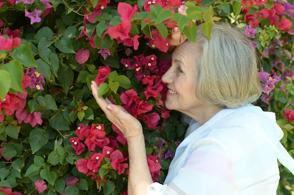 Kvinna med röda blommor — Stockfoto