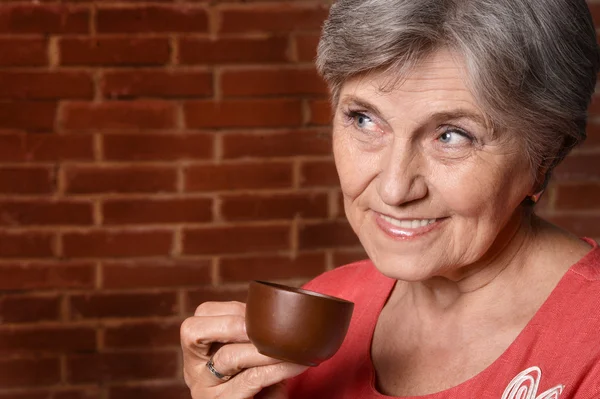 Старшая женщина с чашкой — стоковое фото