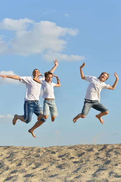 Far och pojkar på en strand — Stockfoto