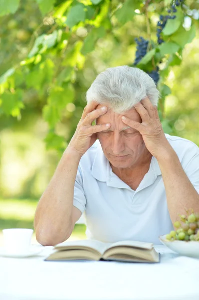 Oudere man rust aan tafel — Stockfoto