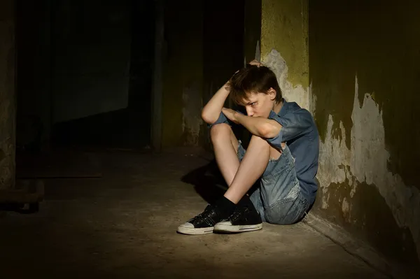 Niño solitario en un sótano oscuro —  Fotos de Stock