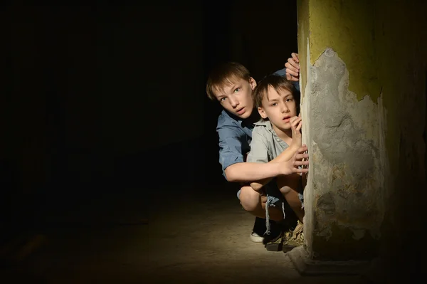 Two lonely little boys   in a dark cellar — Stock Photo, Image