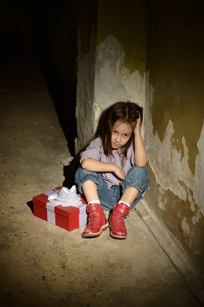 Lonely little girl   in a dark cellar — Stock Photo, Image