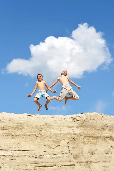 Dois meninos pulando de uma colina — Fotografia de Stock