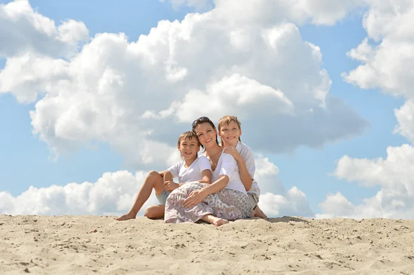Zittend op een zand en gelukkige familie — Stockfoto