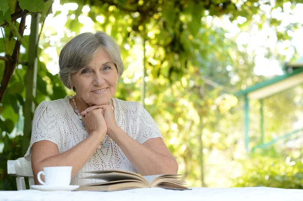 Seniorin im Sommer am Tisch — Stockfoto