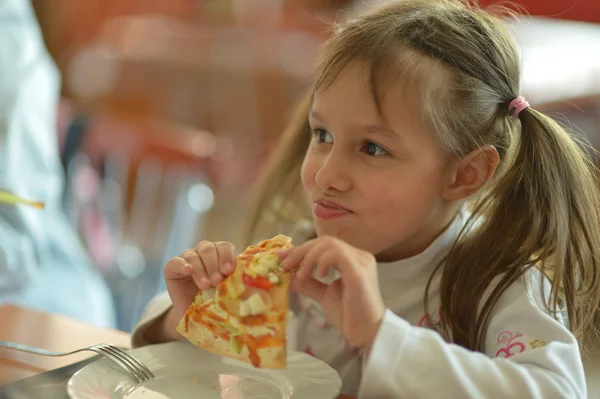 Malá holka jíst pizzu — Stock fotografie