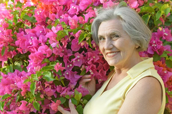 Oudere vrouw met bloemen — Stockfoto