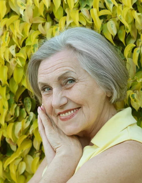 Senior vrouw op groene bladeren — Stockfoto