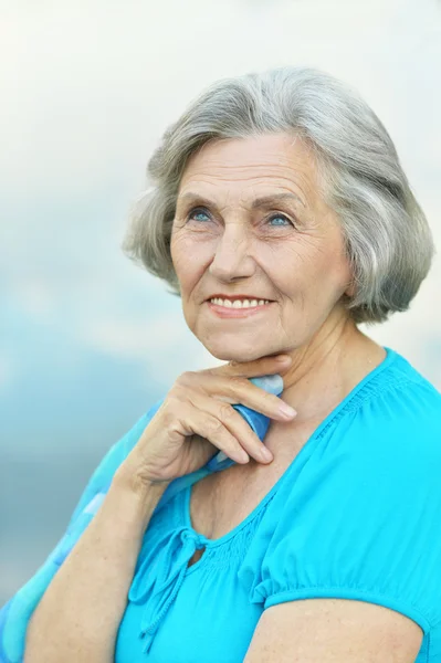 Äldre kvinna på himmel bakgrund — Stockfoto