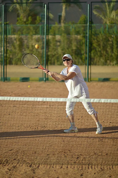 Äldre kvinna spela tennis — Stockfoto