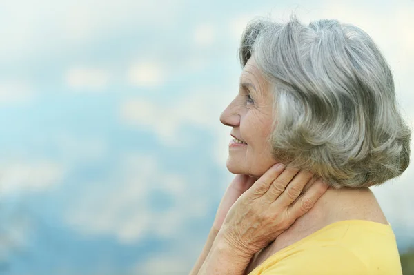 Senior woman on sky background — Stock Photo, Image