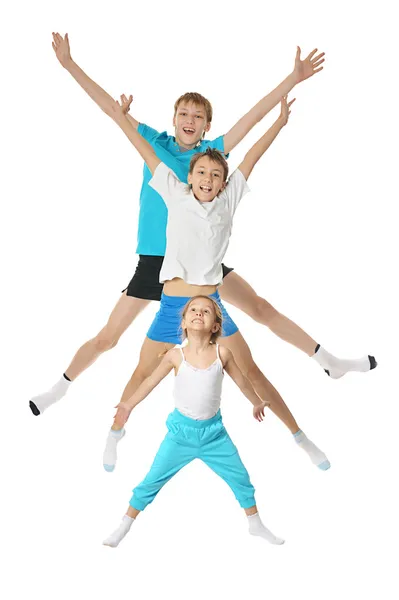 Два мальчика и девочка упражняются — стоковое фото