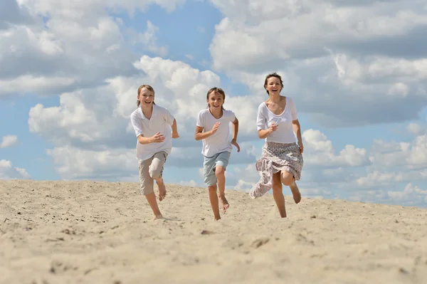 Mutter mit Söhnen auf Sand — Stockfoto