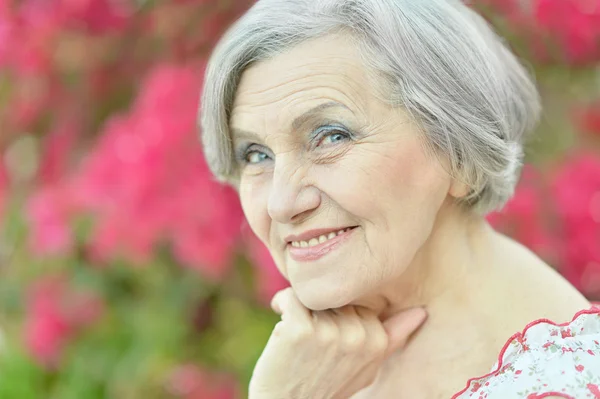 Older woman with flowers — Stock Photo, Image