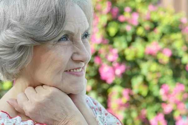 Äldre kvinna med blommor — Stockfoto