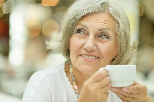Счастливая пожилая женщина пьет чай — стоковое фото