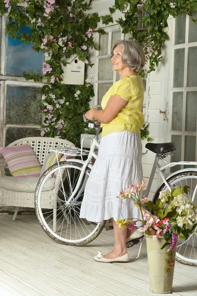 Äldre kvinna med cykel — Stockfoto