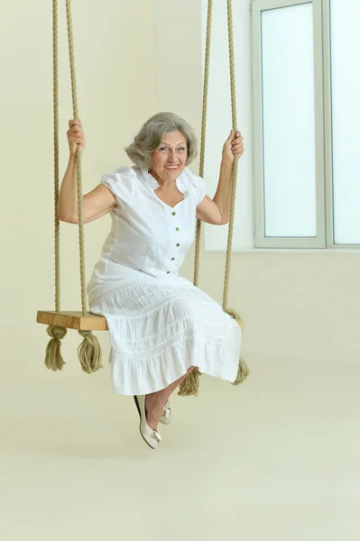 Oudere vrouw op schommel — Stockfoto