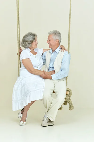 Elderly couple on swing — Stock Photo, Image