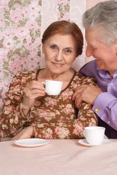 Feliz pareja de ancianos sentados en la mesa —  Fotos de Stock