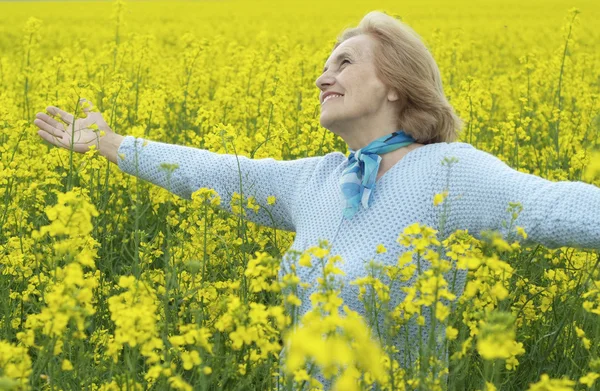 Schöne alte Frau im gelben Feld — Stockfoto