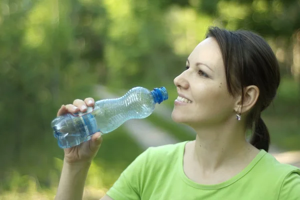 Schöne Frau trinkt Wasser und ruht sich aus — Stockfoto