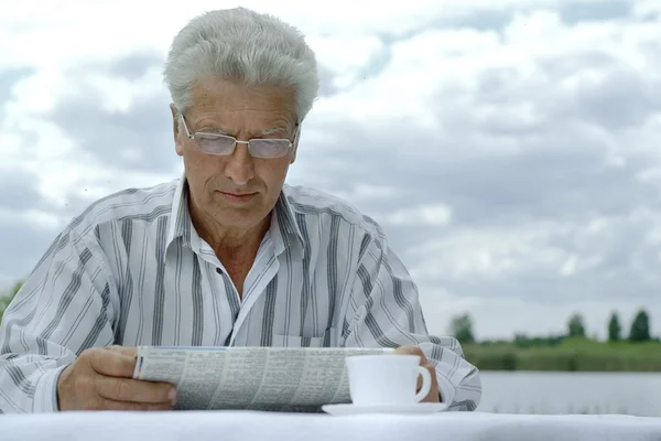 Attractive older man reading newspaper — Stock Photo, Image