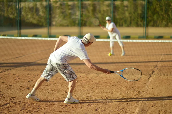 Couple senior jouant au tennis — Photo