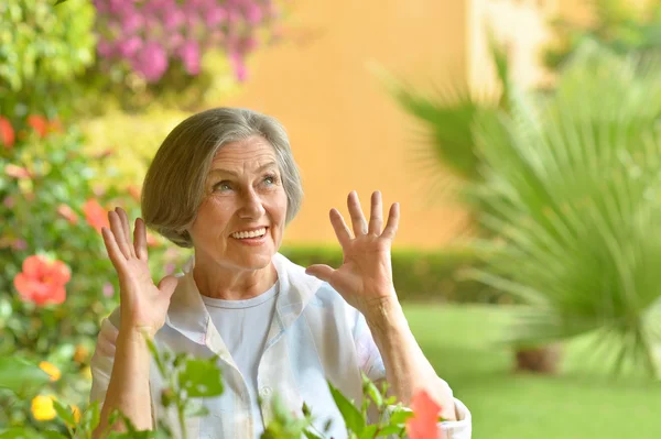 Äldre kvinna med blommor — Stockfoto