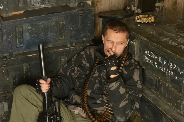 Átgondolt felfegyverzett katonával ül — Stock Fotó