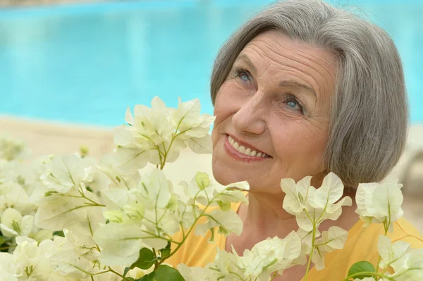 Older woman with white flowers — Stock Photo, Image