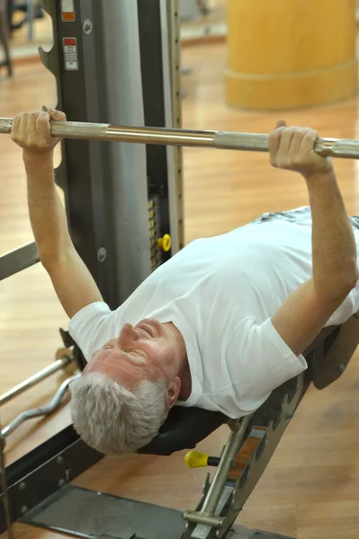 Anciano practicando deportes en un gimnasio — Foto de Stock