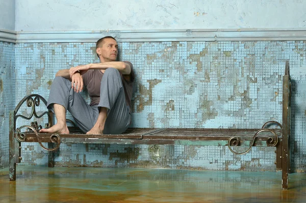 Hombre en la cama oxidada de metal en la cárcel — Foto de Stock