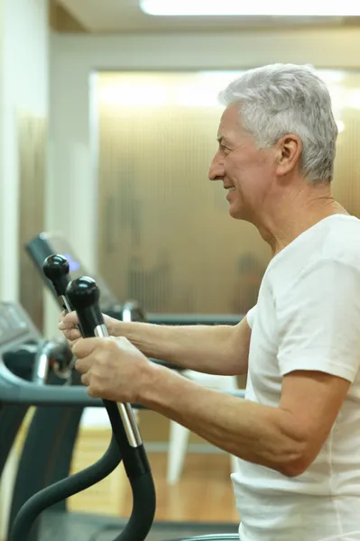 Homme âgé faisant du sport dans une salle de gym — Photo