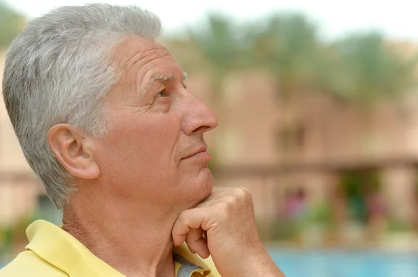 Pensando en un hombre mayor sonriente en el resort — Foto de Stock