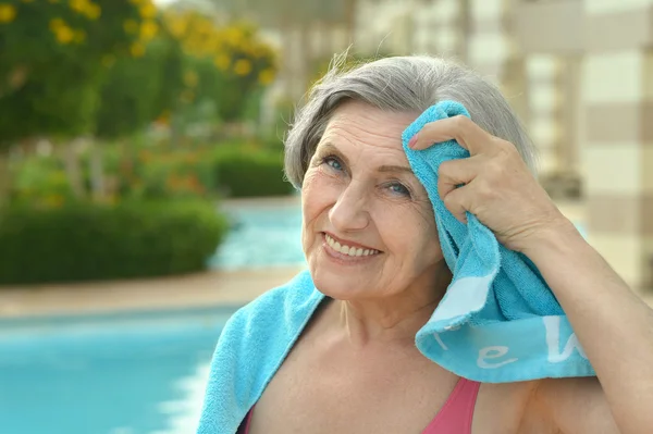 Старшая женщина у бассейна с полотенцем — стоковое фото