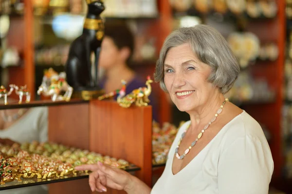 Mujer mayor en tienda de souvenirs —  Fotos de Stock