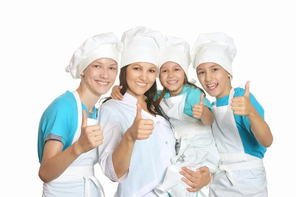 Шеф-повар с помощниками, показывающими большие пальцы — стоковое фото