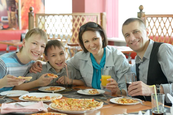 Leende familj äta pizza — Stockfoto