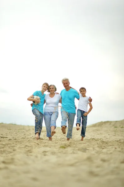 Mor-och farföräldrar med barnbarn på stranden — Stockfoto