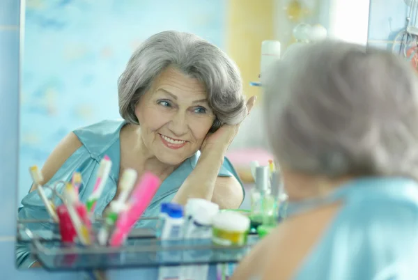 Mujer haciendo maquillaje en el baño — Foto de Stock