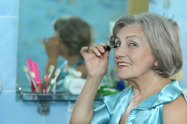 Mujer jubilada haciendo maquillaje — Foto de Stock