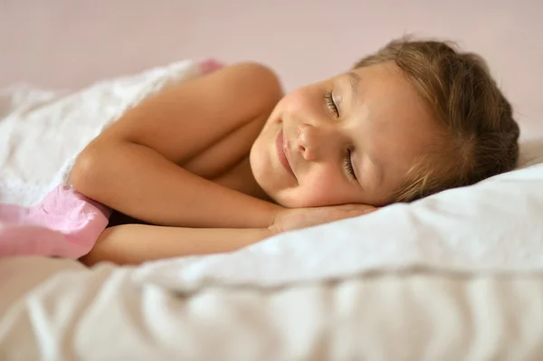 Flicka sover i sin säng — Stockfoto
