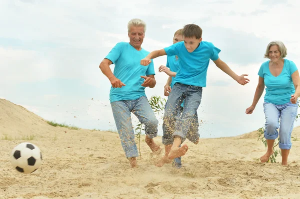 Familie spielt Fußball am Strand — Stockfoto