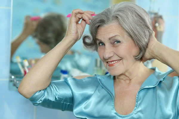 Vrouw doen make-up in de badkamer — Stockfoto