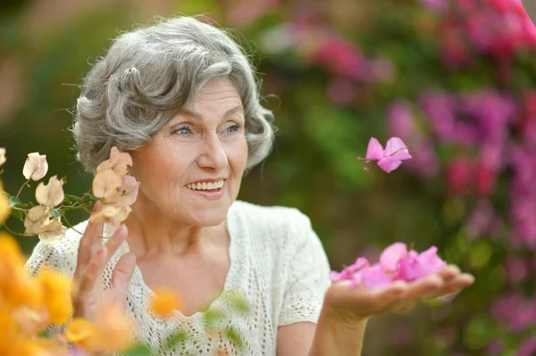 Старшая женщина с цветами — стоковое фото